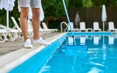 a service person cleaning the swimming pool and lo 2021 09 15 04 59 14 utc What Is Pool Shock? Types, Timing, and How It Differs from Daily Chlorine